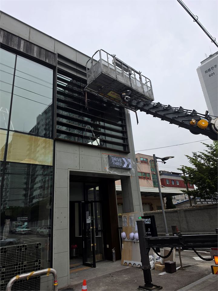 건물 상부 부착물 옆 스카이차 작업대